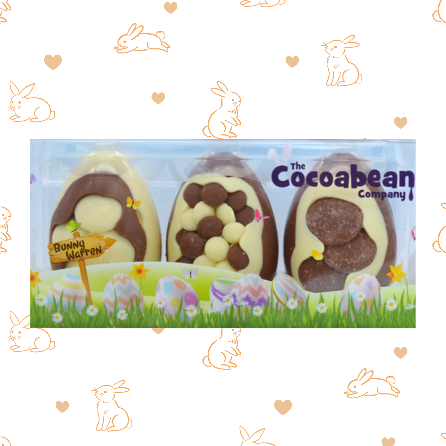 Packaged chocolate Easter eggs with 'The Cocoabean Company' branding on a decorative background with bunnies and hearts.