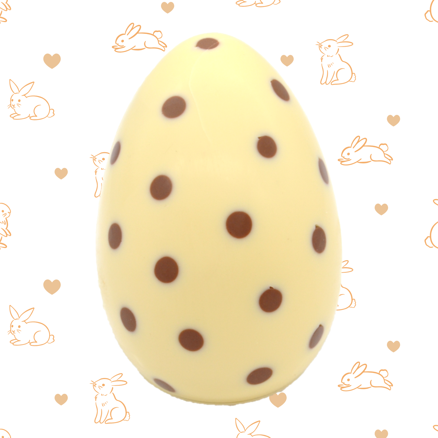 White Chocolate Easter egg with brown spots on a patterned background with bunnies and hearts.