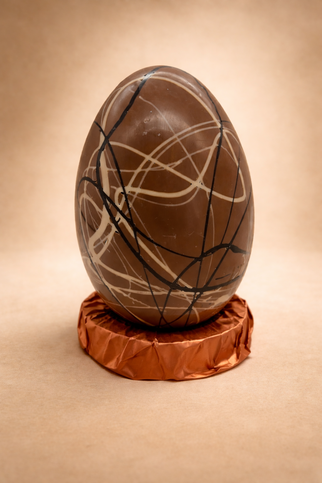 Decorative egg with artistic lines on a brown stand against a beige background