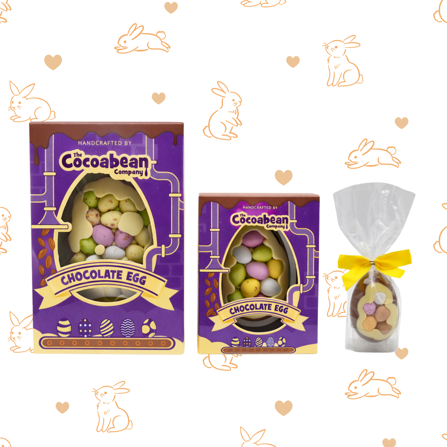 Two purple Cocoabean Company chocolate egg packages with a clear bag containing an egg on a decorative background with bunnies and hearts.