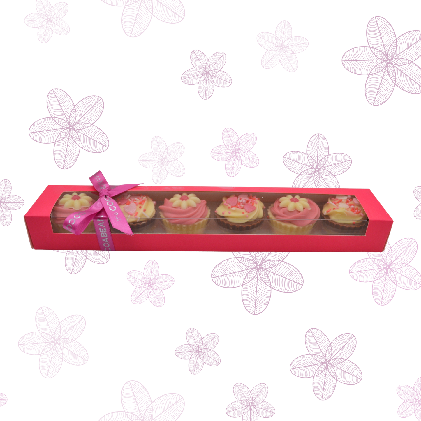 Box of cupcakes with pink ribbon on a floral patterned background