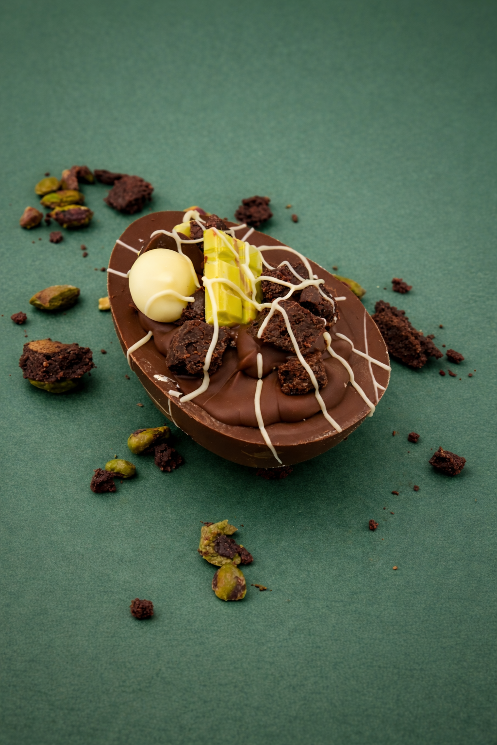 Chocolate easter egg with ice cream and nuts on a green background